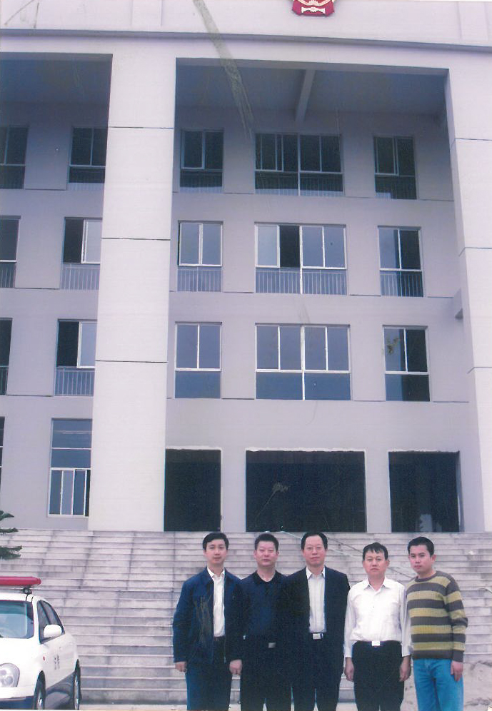 2006年10月18日，投资800多万元，占地面积6248㎡的新建办公大楼主体工程竣工，时任院长李鸣及部分干警在新办公楼前合影（右二为周瑜）.jpg